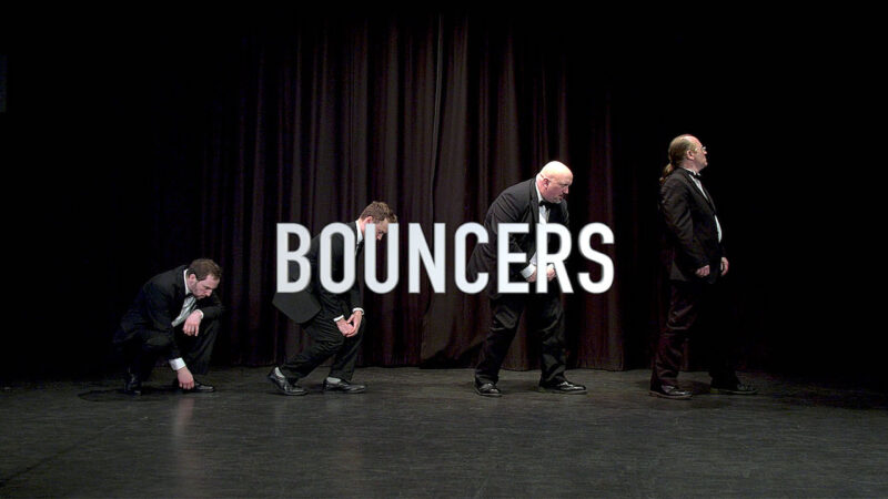 Marketing video still image showing members of a theatre production on stage.