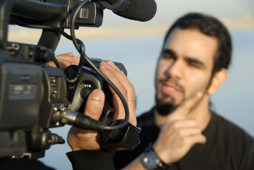 Image of young man with beard being filmed for a corporate video.